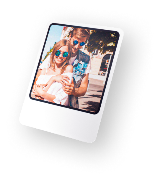 Man with arm around woman's shoulder walking on street wearing sunglasses on sunny day.