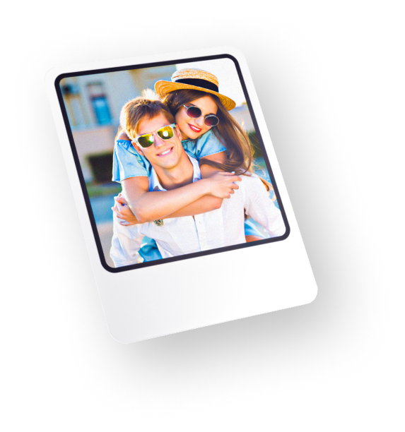 Man hugging woman from behind both wearing sunglasses on sunny day.